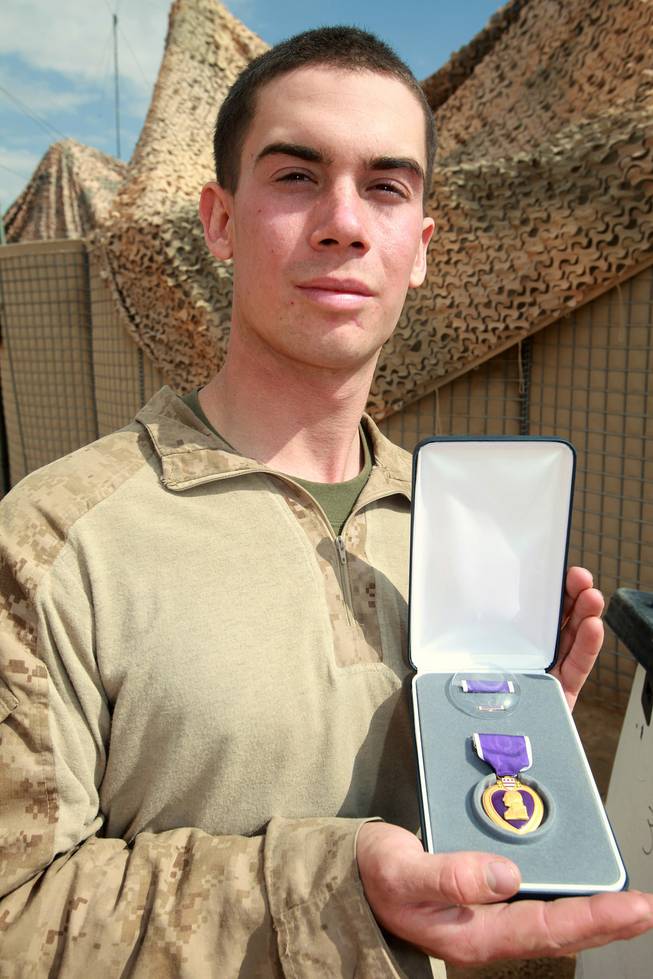 Lance Cpl. Samuel Martin, Jr., (center) 20, of Henderson, Nev., and a rifleman and scout with Apache Co., 3rd Light Armored Reconnaissance Battalion, poses with his Purple Heart medal after receiving the award at Patrol Base South Station, Helmand province, Afghanistan, on March 5.