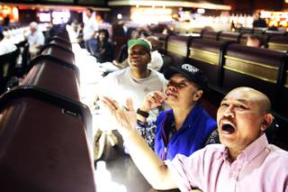Thanomkeo Hanesana, right, and his wife, Jiamjit, of Las Vegas watch basketball games at the Race and Sports SuperBook at the Las Vegas Hilton Tuesday, March 15, 2011.