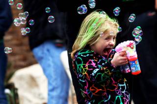 Four-year-old Keeley Karaffa plays with a bubble gun Saturday, March 19, 2011, during the 45th annual Sons of Erin St. Patrick's Day Parade down Water Street in Henderson.