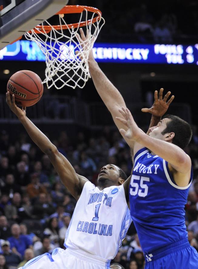 North Carolina's Dexter Strickland (1) drives past Kentucky's Josh Harrellson (55) during the first half of the final of the NCAA men's college basketball tournament East regional, Sunday, March 27, 2011, in Newark, N.J.