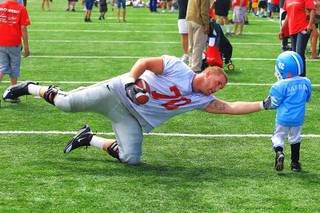 Offensive lineman Jason Heath attempts a pretend tackle on Demil Harris during UNLV's annual spring intrasquad football game Saturday, April 2, 2011.