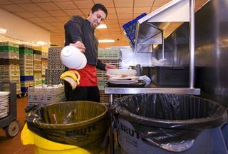 Buffet server Ismael Vidales empties food scaps into a yellow recycling bucket at the Mirage buffet kitchen Monday, April 12, 2011. The food scaps will go to feed pigs at R.C. Farms in North Las Vegas.