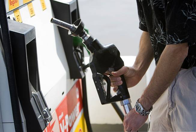 Kurtis Keeler of Jamestown, New York, replaces a pump after filling up at a gas station on Blue Diamond Road Thursday, April 14, 2011. 