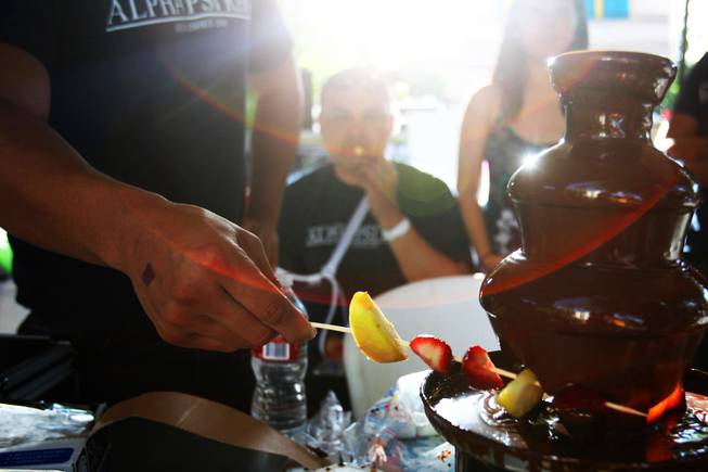 A member of the Alpha Psi Rho fraternity prepares a fruit kabob dipped in a chocolate fountain during UNLVs annual Festival of Communities on the UNLV campus Saturday, April 16, 2011.