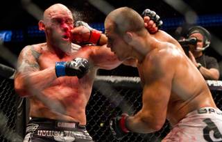 Junior Dos Santos, right, of Brazil, hits Shane Carwin, of Greeley, Colo., during their main event heavyweight mixed martial arts bout at UFC 131, Saturday, June 11, 2011, in Vancouver, British Columbia. Dos Santos won by decision.