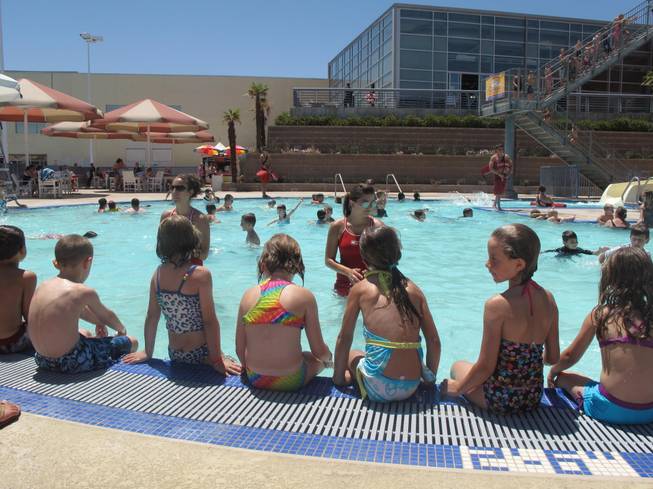 Children at the Henderson Multigenerational Center pool listen to lifeguards as they prepare to start their swim lesson Tuesday morning. The swimmers were part of an international attempt to break the record for the world's largest swim lesson.
