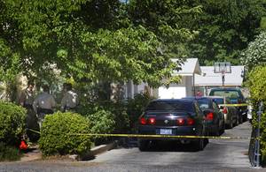 Metro Police officers, left, confer after an officer shot a pit bull at a home near Shetland Road near Charleston Boulevard Saturday, June 25, 2011. The officer was looking for a subject with an outstanding warrant when the dog broke through a fence, police said.