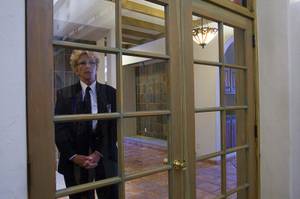 A security officer watches guests though a French doors at a home where entertainer Michael Jackson used to live on Palomino Lane Saturday, June 25, 2011. The homeowner opened a portion of the home to the public to mark the second anniversary of the entertainer's death.