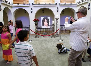 A man takes a photo at a home where entertainer Michael Jackson used to live on Palomino Lane Saturday, June 25, 2011. The homeowner opened a portion of the home to the public to mark the second anniversary of the entertainer’s death.