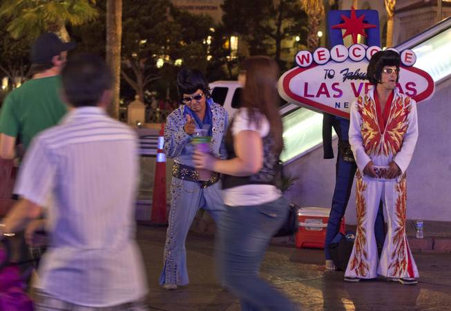 Tony Gallardo, left, and Rodrigo Gonsalez work together impersonating Elvis along The Strip, Thursday, June 23, 2011, in Las Vegas.  The number of celebrity impersonators crowding the Las Vegas Strip has grown in recent months, in part because the stalled economy has left many actors and performers in California and Las Vegas without a job. 