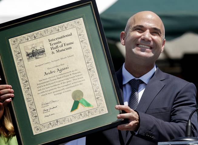 Tennis great Andre Agassi holds his plaque as he is inducted into the International Tennis Hall of Fame in Newport, R.I., on Saturday, July 9, 2011.