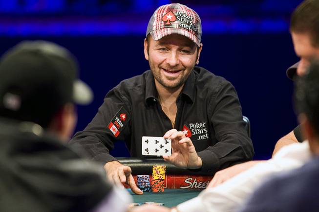 Poker professional Daniel Negreanu of Canada shows his card to an opponent after winning a hand during the World Series of Poker main event at the Rio Monday, July 11, 2011.
