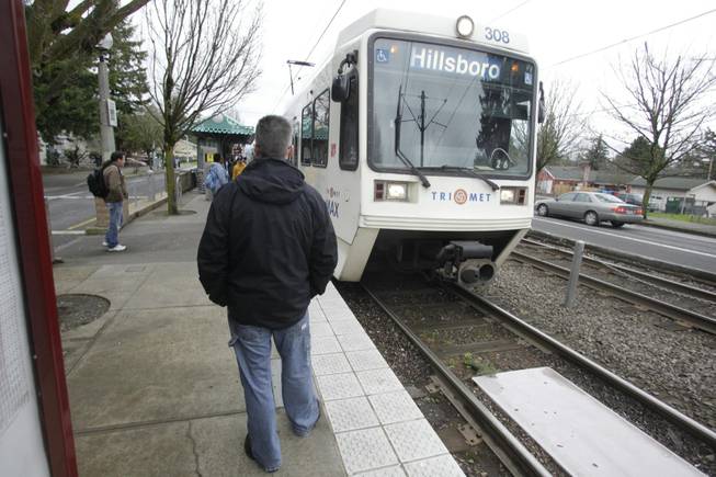 Scott Nielsen waits for a train at the TriMet light rail stop at 162nd Avenue Wednesday, March 30, 2011, in Portland, Ore.