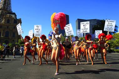 Showgirls from “Jubilee!” at Bally’s march up the Strip during a publicity stunt Thursday, July 21, 2011, to praise Caesars Entertainment’s policy of not charging resort fees.