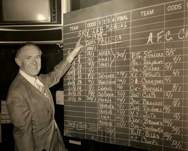 Jackie Gaughan, the previous owner of the El Cortez, stands in front of a board featuring the odds of where pieces of the Skylab satellite would crash to earth. The photograph is on display on the El Cortez Casino floor.