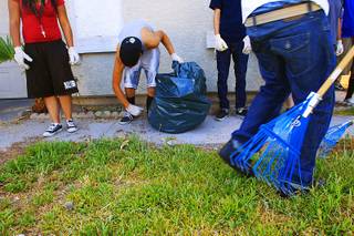 Youth offenders clean up the yard of a foreclosed home Thursday, July 28, 2011.