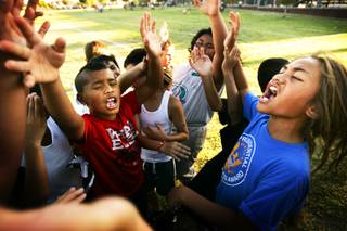 Members of the Island Warriors team cheer after a drill at football practice at Liberty High School in Henderson Thursday, August 4, 2011.
