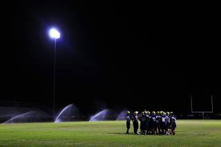 Spring Valley players huddle during their annual midnight football practice to kick off the season Thursday, August 11, 2011.