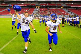 Moapa players Taylor Schwartz (52) and Jovan Romero (8) run to the sidelines after their game against Show Low at the Sollenberger Classic Saturday, August 20, 2011 at the University of Phoenix Stadium in Glendale, Arizona. Moapa upset the Arizona Class 4A state champions 28-26.