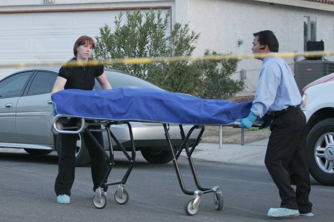 In this 2009 file photo, officials with the Clark County coroner's office remove bodies from the scene of what authorities suspected to be a murder-suicide. Reality TV producers want to pay the county $5,000 per episode to follow coroner's office employees on their jobs.