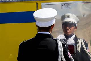 Joe Page, a member of the Clark County Fire Department honor guard, uses the reflective side of his fire engine as a mirror as he gets ready for a 9/11 memorial ceremony at Police Memorial Park on Sunday, Sept. 11, 2011.