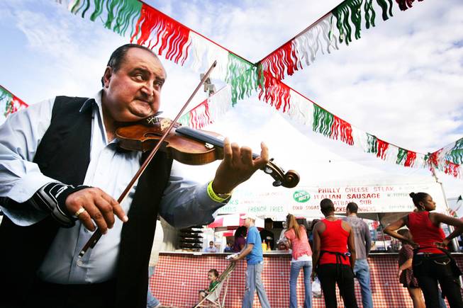 Violin player Sandor Beke entertains the crowds near the food booths during the San Gennaro Feast at the Rio on Wednesday, Sept. 14, 2011.