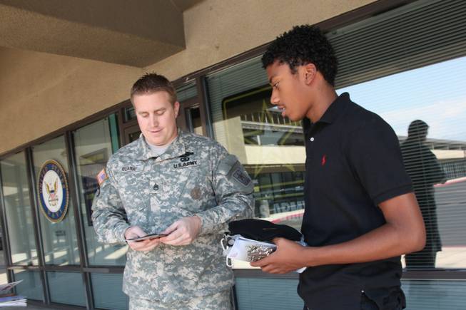 Sgt. Jonathan Quarry, in charge of the Decatur Boulevard military recruiting station, talks with Brandon Smith, 18, about potential careers in the armed services. The military today is recruiting fewer young people and enlistment standards have become more competitive.