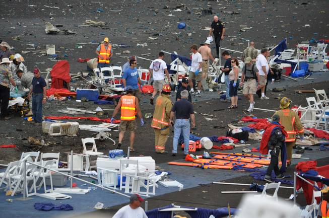 A crowd gathers around debris after a P-51 Mustang airplane crased at the Reno Air show on Friday, Sept. 16, 2011 in Reno Nev.. The plane plunged into the stands at the event in what an official described as a "mass casualty situation."