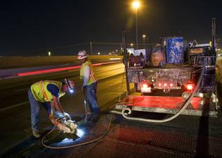 Higinio Arrenondo and Patrice Whitlaw prepare a section of road for a patch during resurfacing of Interstate 15 between Tropicana Avenue and Charleston Boulevard on Monday, Sept. 19, 2011.