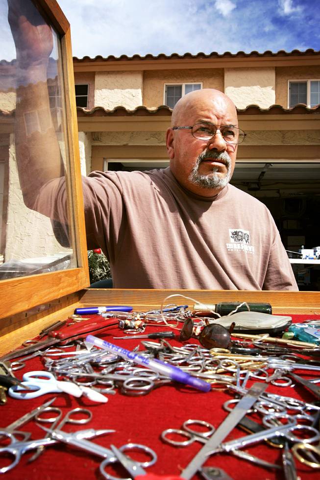 Dave Muzerolle with his collection of TSA-confiscated sharp items for sale at his friend's house Saturday, Sept. 24, 2011.
