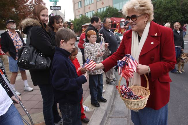 Las Vegas Mayor Carolyn Goodman hands a flag to Taylor Cochran, 11, during the annual Veterans Day parade on 4th Street in downtown Las Vegas on Friday Nov. 11, 2011.