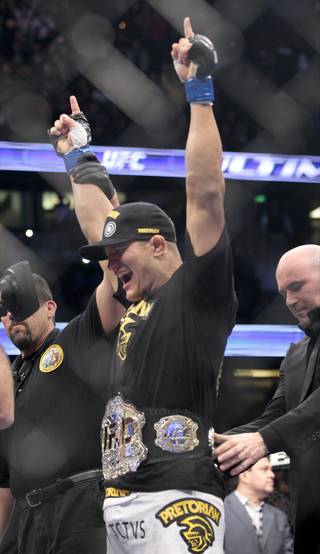 Junior dos Santos, of Brazil, gets the title belt after defeating Cain Velasquez in the UFC mixed martial arts heavyweight title bout, Saturday, Nov. 12, 2011, in Anaheim, Calif. 