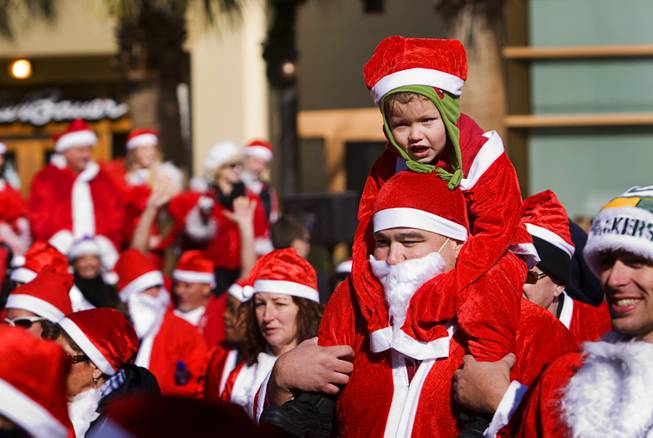 Ryan Cabrera, 4, has the easy end of it as he rides on his father's shoulders during the annual Las Vegas Great Santa Run at Town Square Saturday, December 3, 2011.