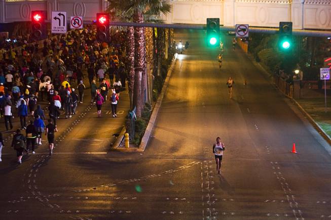 Runners, at left, head northbound on the Las Vegas Strip ...