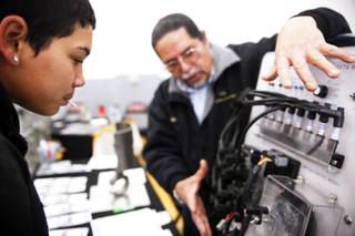 Junior Dominic Cardenas, left, checks out a demonstration by instructor Edgardo Rapala of the College of Southern Nevada Transportation Technologies Program during a job fair at Chaparral High School in Las Vegas Tuesday, December 6, 2011.