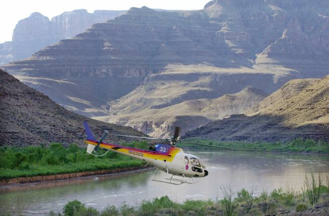 A Eurocopter AS350, similar to the Sundance Helicopters aircraft that crashed Wednesday near Lake Mead, is shown taking off in front of a section of the Grand Canyon in this 2001 file photo. The helicopter pictured is from a different tour operator.