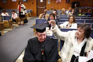 Michael Zone, 90, a Desert Rose High School graduate,gets some help with his tassel from his wife Mary Zone before accepting his diploma during the Clark County School District board meeting at the Greer Education Center in Las Vegas Thursday, December 8, 2011.