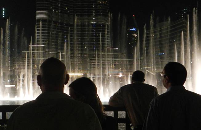 In Dubai, United Arab Emirates, tourists and locals enjoy a display of the Dubai Fountain at the Burj Khalifa complex.  December  2011.