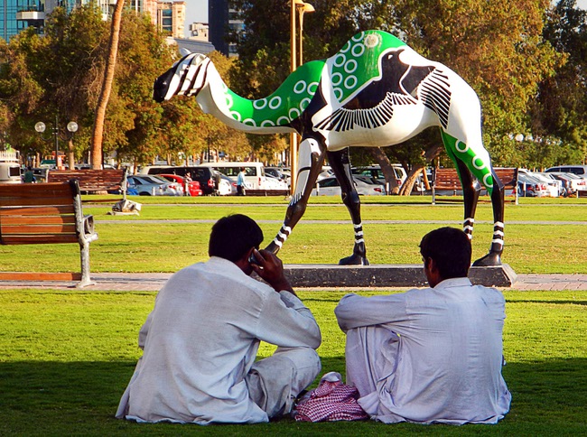 In Dubai, United Arab Emirates, two labor workers relax during their lunch break near Deira Creek.  December  2011.