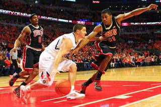 UNLV guard Justin Hawkins defends Illinois guard Sam Maniscalco during their game Saturday, Dec. 17, 2011 at the United Center in Chicago. The Rebels beat the 19th-ranked Illini 64-48.