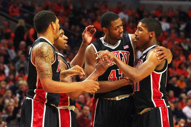 UNLV guard Justin Hawkins is congratulated by teammates, from left, Anthony Marshall, Oscar Bellfield and Mike Moser after drawing a foul against Illinois during their game Saturday, Dec. 17, 2011 at the United Center in Chicago. The Rebels beat the 19th-ranked Illini 64-48.