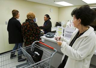 A donor, center, steps up to the counter at the layaway department of a Kmart store on Eastern Avenue in Henderson on Dec. 20, 2011 to pay on the account of Jennifer Wells, left, and another customer. Layaway customer Barbara Poole looks on at right. Anonymous donors, dubbed 