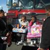 As their father Antonio Harris watches, Trenton, 4, and  Tristina, 3, open the gifts they received Wednesday afternoon from the fire dispatchers at Operation Fire H.E.A.T.
