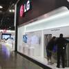 Workers arrange a display of home appliances at an LG Electronics booth at the Consumer Electronics Show at the Las Vegas Convention Center on Jan. 8, 2012. 
