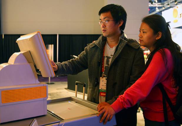 Yi Ding and his wife Ariel of Los Angeles use a Kodak photo kiosk during the 2012 International Consumer Electronics Show (CES) in Las Vegas, Nevada, Jan. 11, 2012. The Internet-enabled kiosk lets you print photos from your Facebook account and the accounts of your friends, subject to privacy restrictions. CES, the world's largest consumer technology tradeshow, runs through Friday.