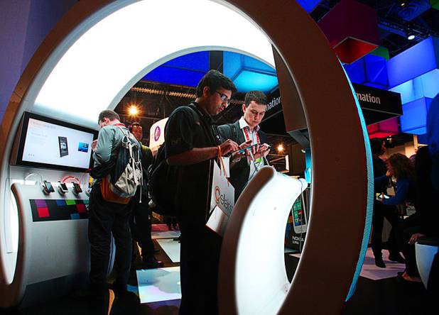 Soham Sheth (C) of San Diego and Vladimir Vasilev (R) of Russia look over Nokia smartphones during the 2012 International Consumer Electronics Show (CES) in Las Vegas, Nevada, Jan. 11, 2012. CES, the world's largest consumer technology tradeshow, runs through Friday.