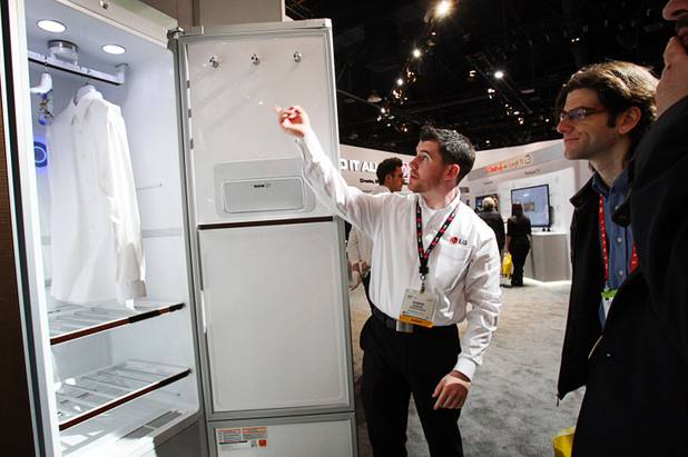Damien Check (C) shows off a Tromm Styler clothes manager at the LG Electronics booth during the 2012 International Consumer Electronics Show (CES) in Las Vegas, Nevada, Jan. 11, 2012. The closet uses steam to sterilize and remove odors and wrinkles from clothing. CES, the world's largest consumer technology tradeshow, runs through Friday.