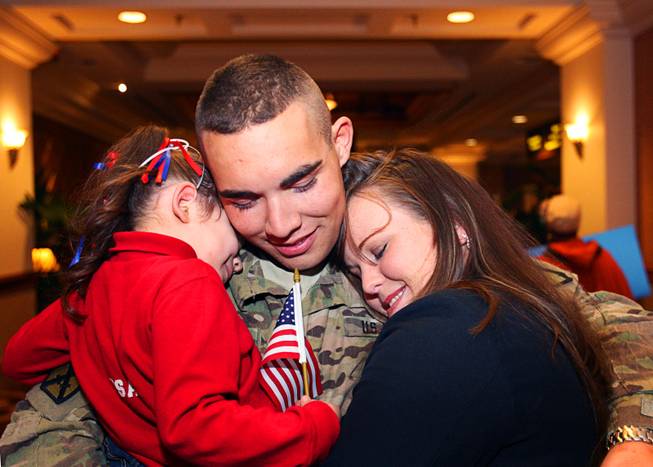 Army National Guard Spc. Michael Sena hugs his daughter Tayler Marie, 3, and his wife Nicole before a welcome home ceremony for the 422nd Expeditionary Signal Battalion at the Mandalay Bay Sunday, January 15, 2012. The Army National Guard soldiers entered field service on January 7, 2011 and have been serving in Afghanistan since March 28, 2011.