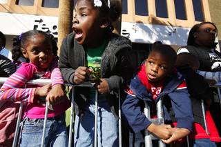 Aryanna Pidgeon, 4, from left, Z'Kya Smith, 5, and Tyler Haynes, 4, all of Las Vegas watch during the Dr. Martin Luther King Jr. Parade in downtown Las Vegas Monday, Jan. 16, 2012.