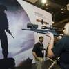 Kenton Schuett of Raton, N.M. looks through a Hensoldt scope equipped with a night vision attachment at the Zeiss booth during the first day of the SHOT (Shooting, Hunting, Outdoor Trade Show) at the Sands Expo & Convention Center Tuesday, Jan. 17, 2012. The company also showed the  ZF 3.5-26X56 FF sniper scope which is the first scope that can compensate for bullet drop at 2000 yards, a representative said.